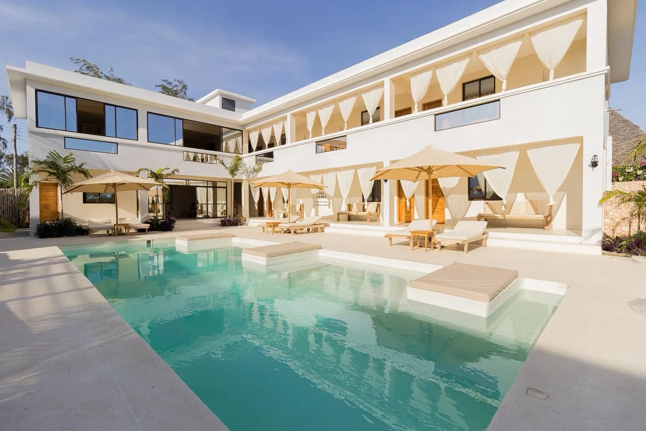 Palm fronds framing the turquoise courtyard pool and its sun loungers